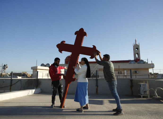 Fedeli issano una croce a Qaraqosh in attesa del Papa