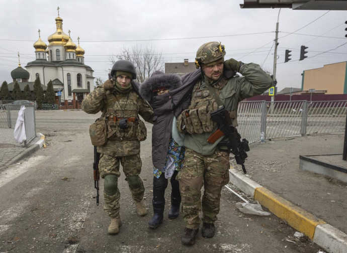 Soldati ucraini soccorrono una civile a Iripin