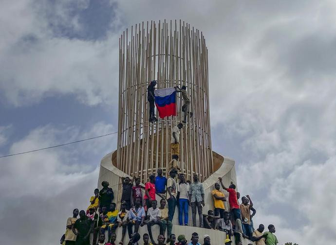 Sostenitori della giunta golpista in Niger issano una bandiera russa dopo il golpe