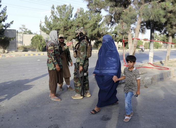 Talebani armati e donna in burqa. Il futuro dell'Afghanistan