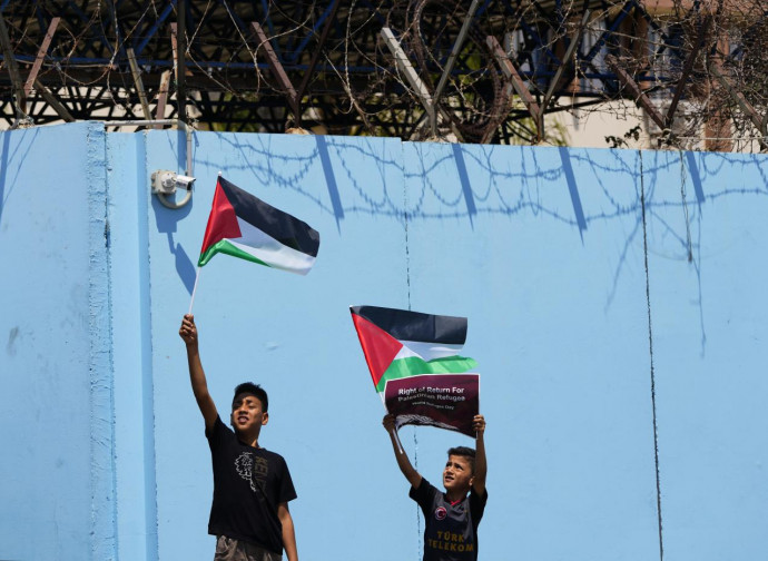 Bambini palestinesi di fronte alla sede dell'Unrwa